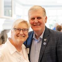 Teresa Beck standing with former President Tom Haas, both giving joyous smiles to the camera